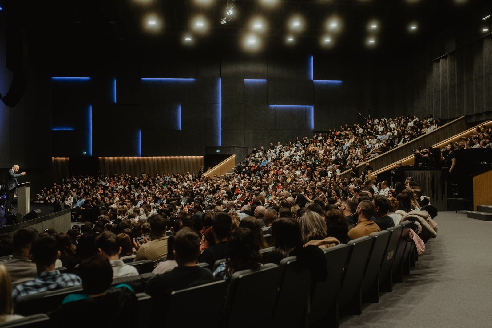 Gran auditorio en blanco y negro con público escuchando a un orador