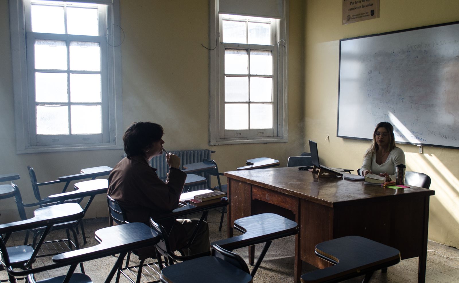 Dos estudiantes conversan en un aula