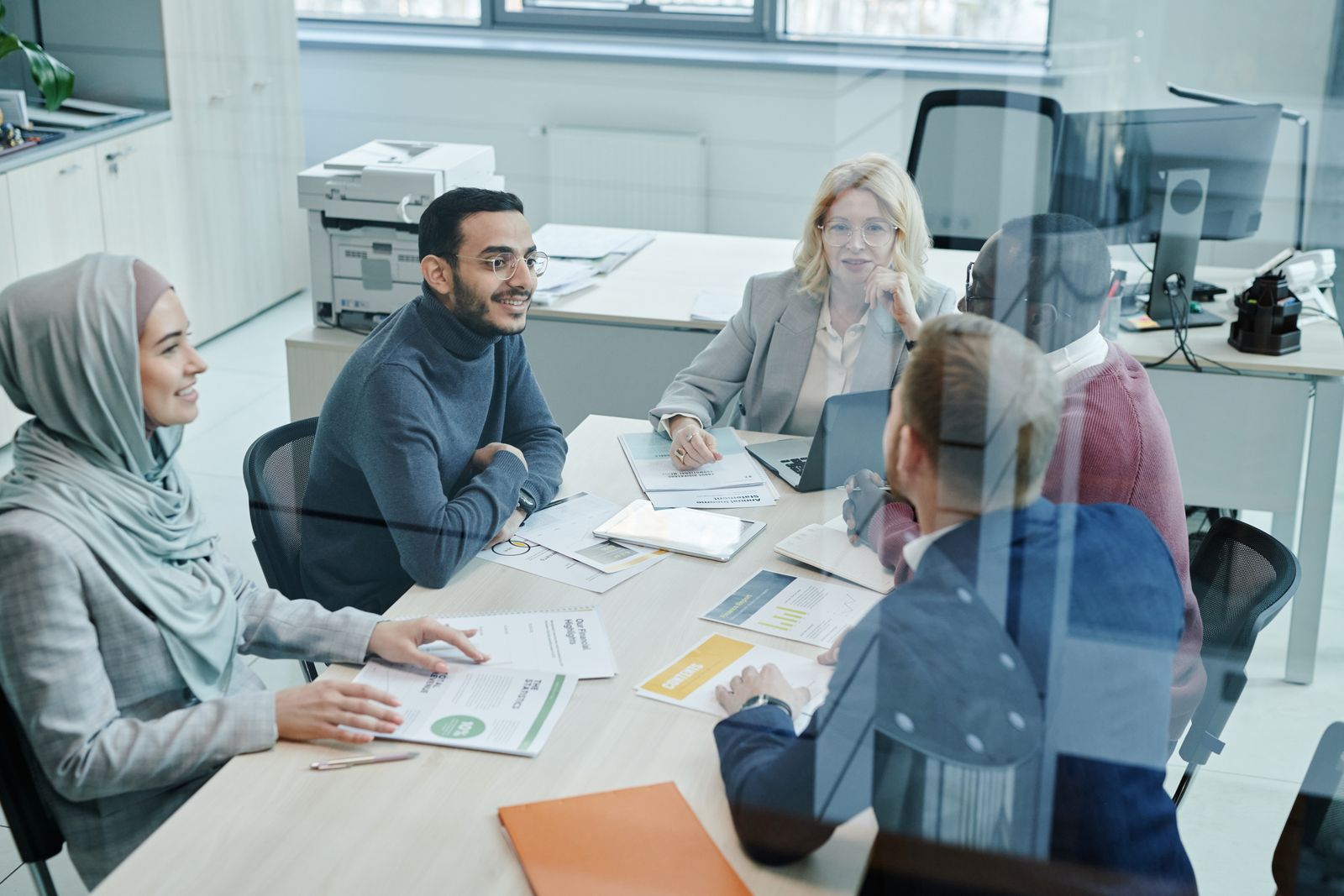 Un equipo diverso reunido alrededor de una mesa de oficina